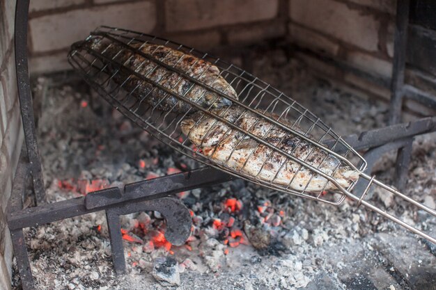 Pescado apetitoso en una rejilla de acero, frito a la parrilla