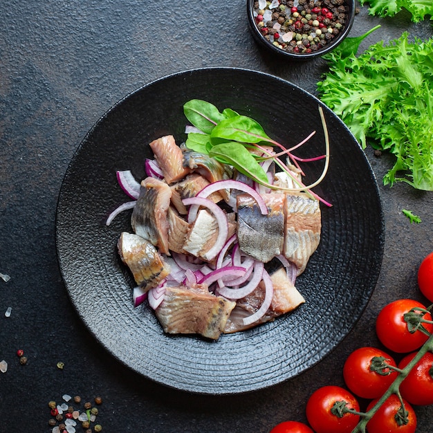 Pescado arenque con ensalada de cebollas en un bol