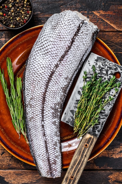 Pescado blanco fresco crudo granadero macrurus sin cabeza. Fondo de madera oscura. Vista superior.