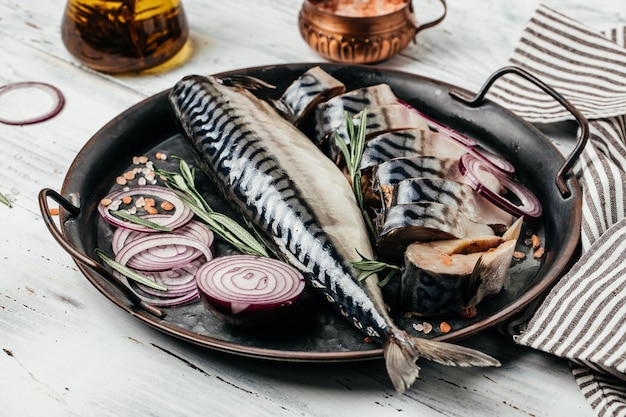 Pescado de caballa fresco delicioso con cebolla sobre fondo de madera. Cocina culinaria saludable. Fondo de receta de comida. De cerca