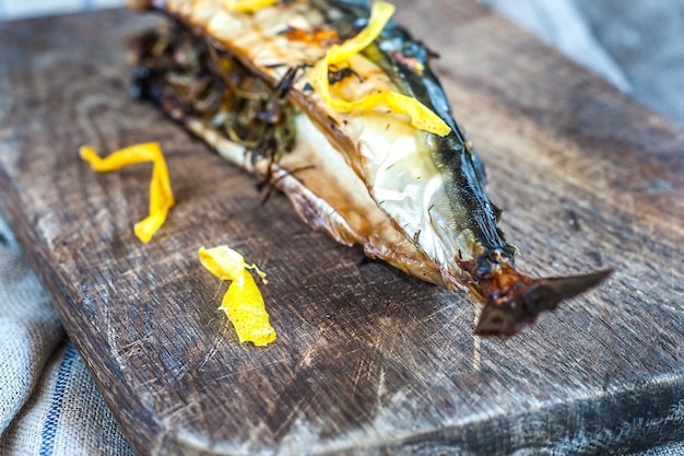 Pescado de caballa en una tabla de madera y una toalla vieja