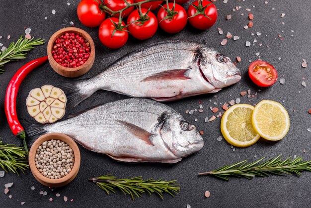 Pescado dorado crudo con especias cocinando en tabla de cortar. Dorado de pescado fresco. Dorado e ingredientes para cocinar en una mesa