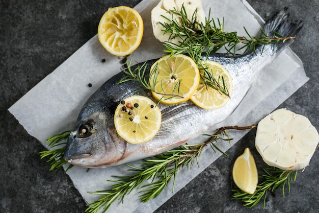 Pescado dorado crudo con especias Dorado e ingredientes para cocinar en una mesa