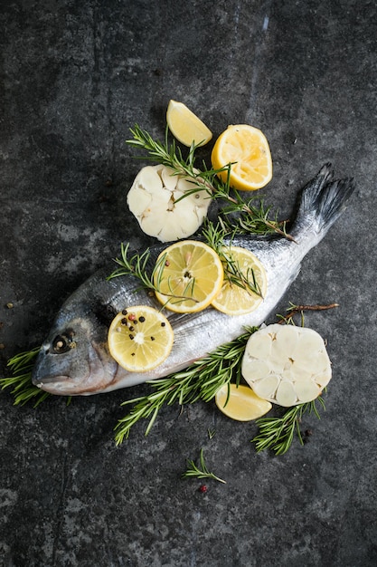 Pescado dorado crudo con especias Dorado e ingredientes para cocinar en una mesa