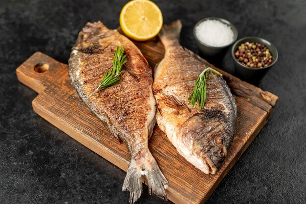 Pescado dorado a la parrilla sobre fondo de piedra