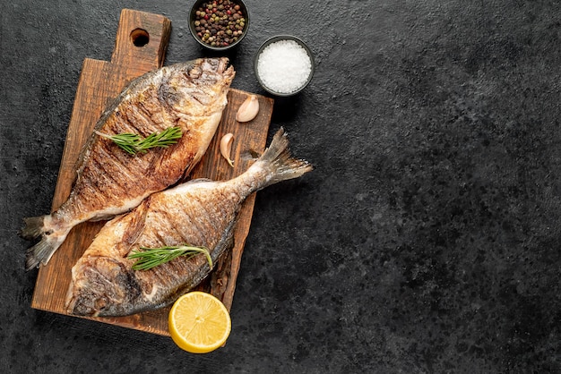 Pescado dorado a la parrilla sobre fondo de piedra