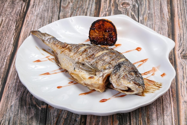 Pescado dorado a la plancha servido con limón y balsámico