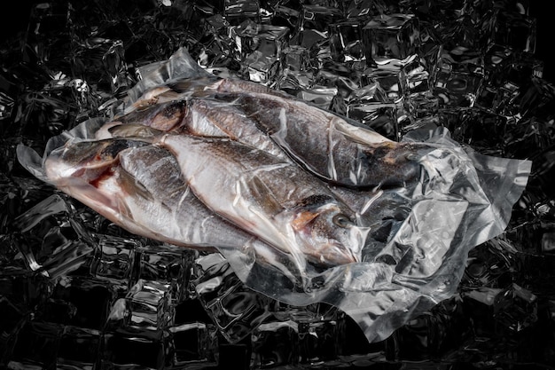 Pescado envasado al vacío sobre fondo oscuro hielo dorada Semiacabado