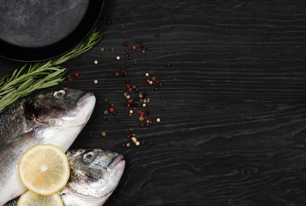 Pescado fresco dorado Dorado e ingredientes para cocinar en una mesa