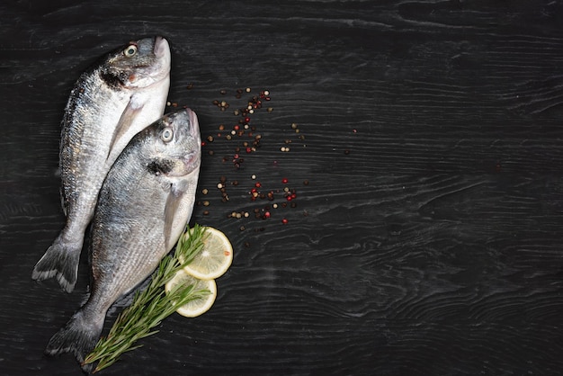 Pescado fresco dorado Dorado e ingredientes para cocinar en una mesa