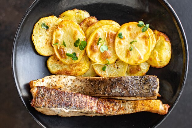 Pescado fresco frito y rodajas de patata adornan omega