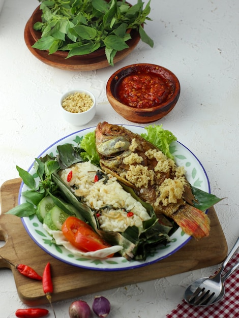 Pescado frito crujiente servido con arroz, vegetales y chile