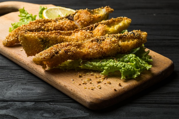 Pescado frito crujiente en una tabla de madera rústica