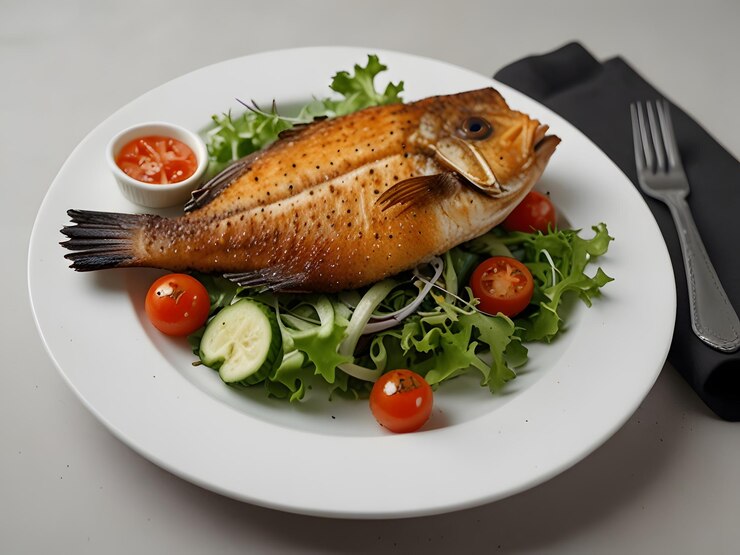 Pescado frito con ensalada en un plato blanco Vista superior