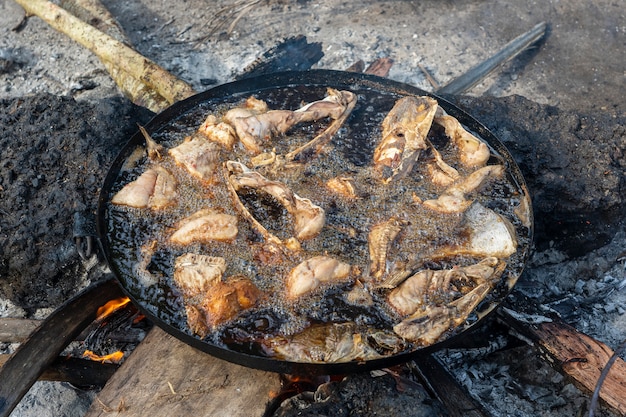 Pescado frito un fuego abierto para la venta en el mercado de la calle, Zanzíbar, Tanzania, África