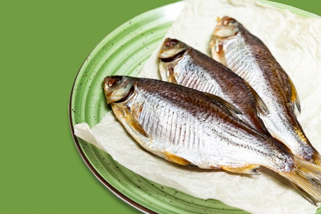 Pescado frito en un plato sobre un fondo blanco.