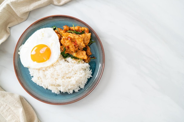 pescado frito salteado con albahaca y huevo frito cubierto con arroz - Estilo de comida asiática