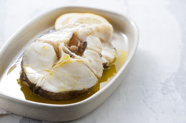 Pescado hervido con aceite de oliva en plato de cerámica