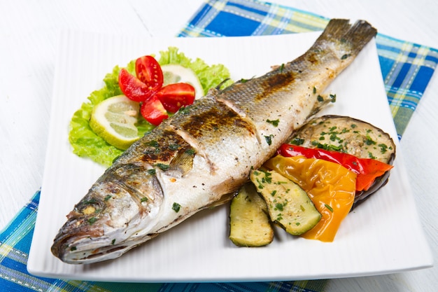 Pescado, lubina a la plancha con limón y verduras a la plancha.