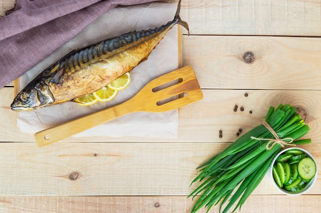 Pescado de mar al horno (caballa) sobre fondo de madera.