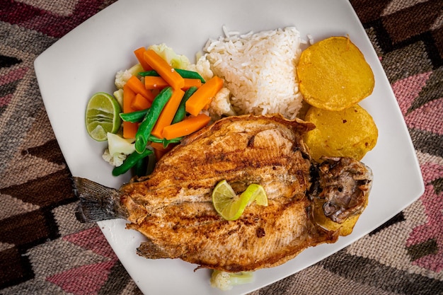 Pescado o trucha frita con ensalada en mesa artesanal