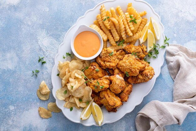 Foto pescado y papas fritas en una bandeja de servicio con salsa de inmersión