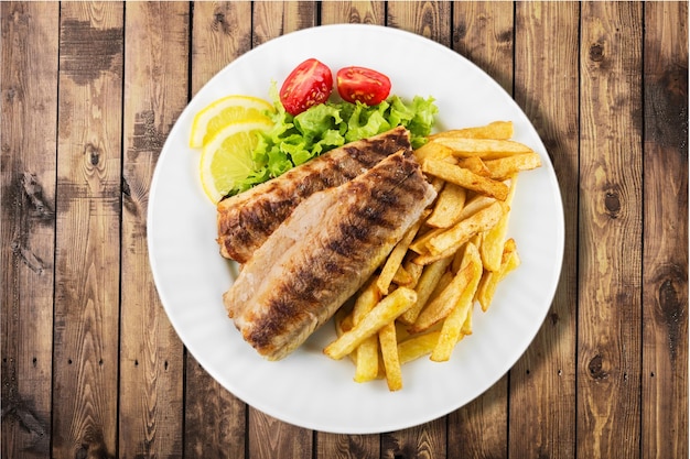 Pescado y papas fritas en un plato blanco