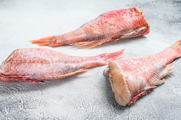 Pescado pargo rojo entero crudo sobre una tabla para cortar