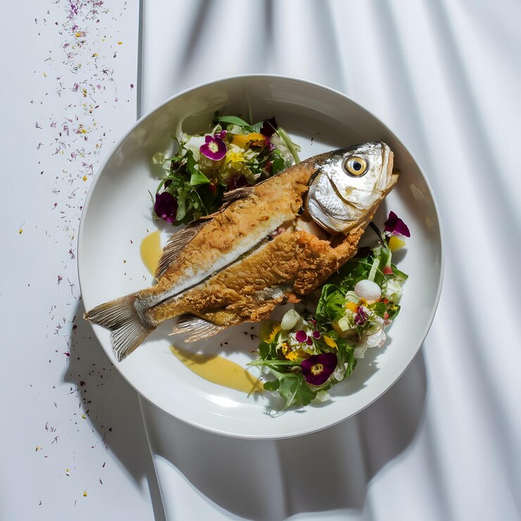 Pescado a la parrilla con rúcula y tomates cereza en un plato blanco