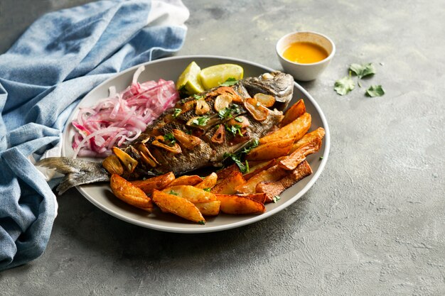 Pescado a la parrilla servido con arroz, cebolla y camote