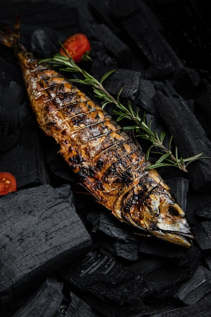 Un pescado a la parrilla con tomates asados