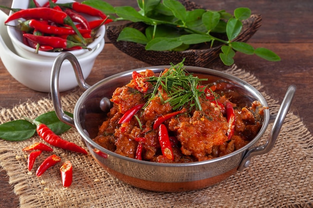 Pescado picante salteado en una sartén sobre una madera