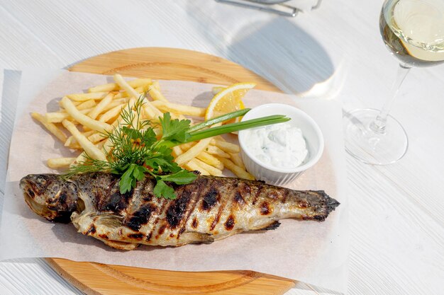 Pescado a la plancha con guarnición de hierbas y patatas fritas