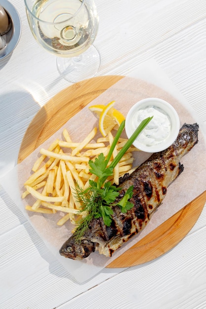 Pescado a la plancha con guarnición de hierbas y patatas fritas