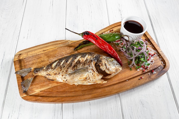 Foto pescado a la plancha con pimiento y verduras y salsa