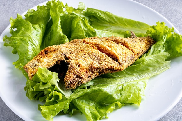 Pescado quotperoaquot frito con ensalada de lechuga Comida tradicional brasileña de playa conocida como quotPeixe Frito Capixabaquot