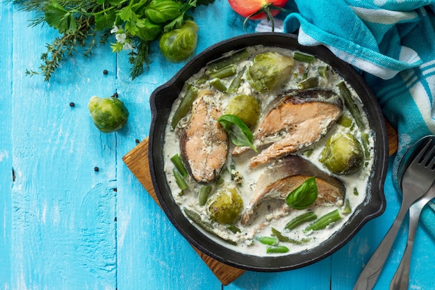 Pescado rojo y verduras coles de Bruselas al horno judías verdes en salsa de crema