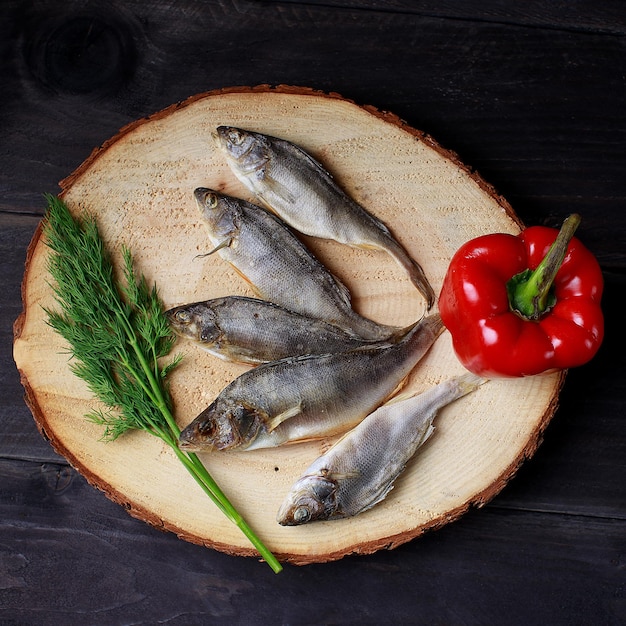 Pescado secado al sol fundidos salados sobre fondo de madera vista superior copia espacio Snack para cerveza fundidos secos