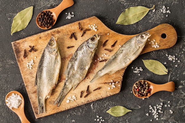 Pescado seco con sal y pimienta en tabla de cortar