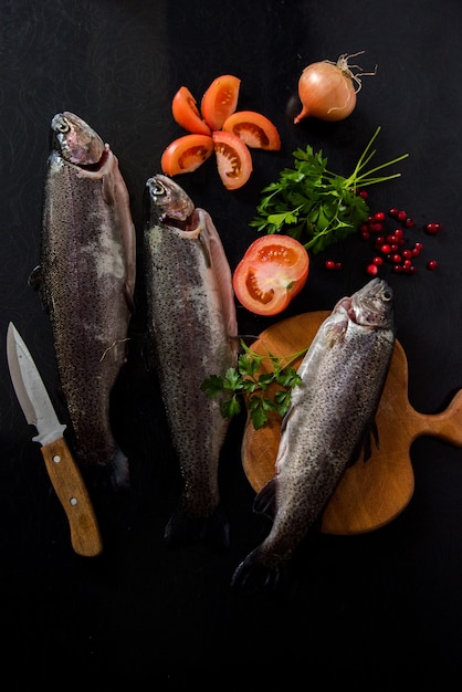 Pescado en una tabla de cortar con verduras frescas