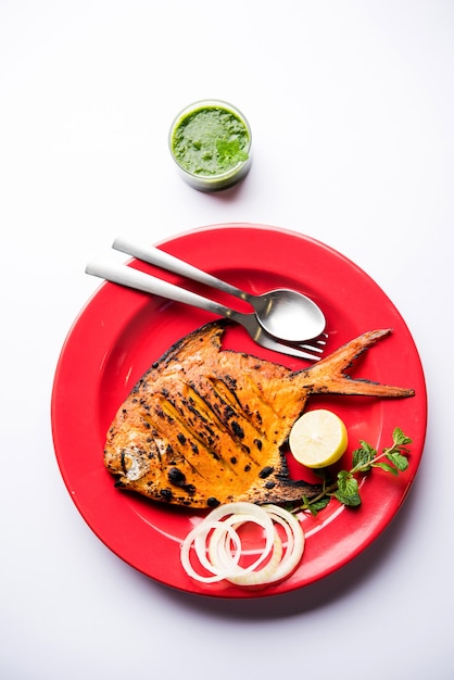 Pescado Tandoori Pomfret cocido en horno de barro y aderezado con ensalada de limón, menta, repollo y zanahoria