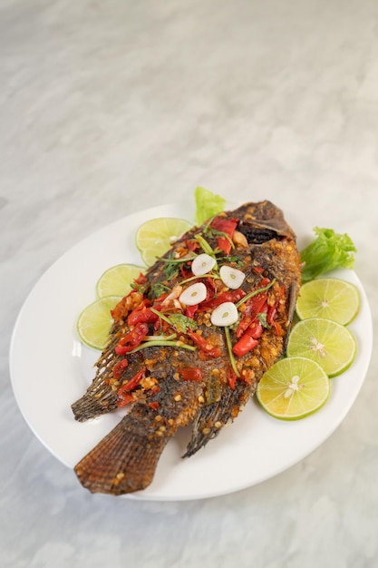 Pescado tilapia entero frito por expertos y bañado en salsa de chile picante para una explosión de sabores