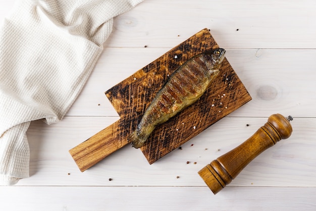 Pescado trucha a la plancha sobre una tabla de madera