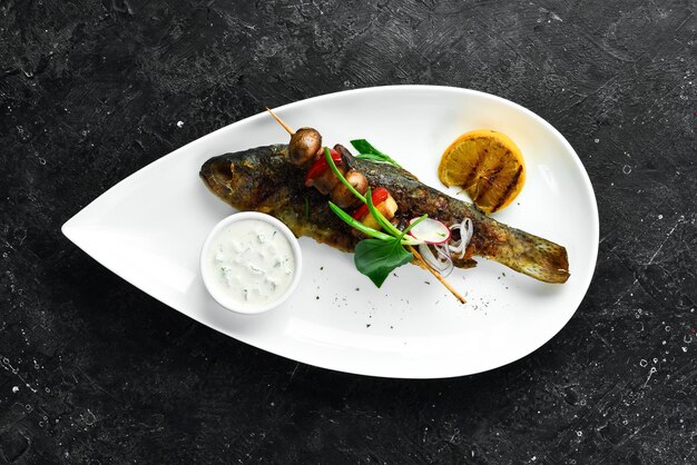 Pescado de trucha de río al horno con verduras en un plato Mariscos Vista superior Espacio libre para texto