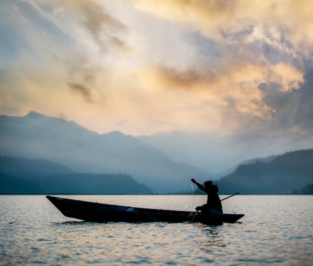 Pescador en el barco de pesca al atardecer