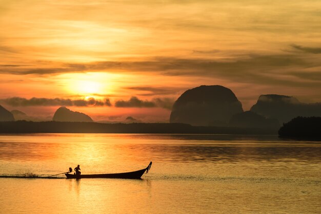 Pescador en barco de pesca local en el pueblo pesquero de Samchong al amanecer en Phang-Nga, Tailandia