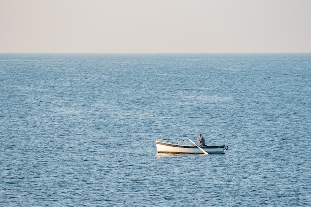 Pescador en un barco de pesca temprano en la mañana. Mar Mediterráneo. Italia.