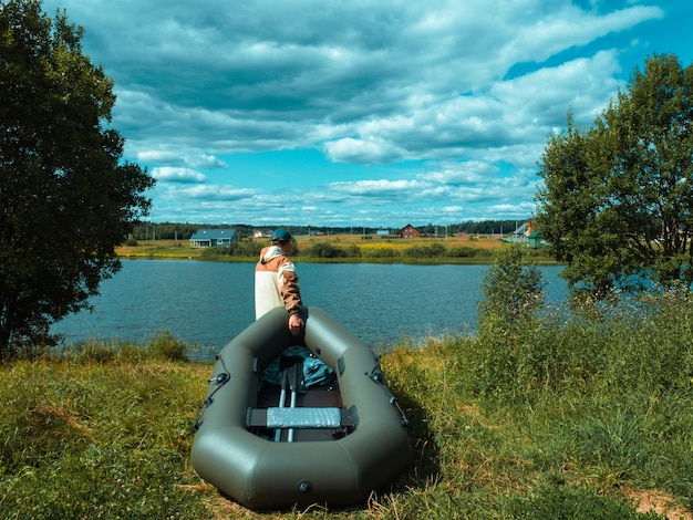 Un pescador con un bote baja al río.