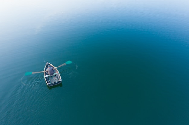 Pescador en un bote de madera remos, vista superior. Enfoque suave.