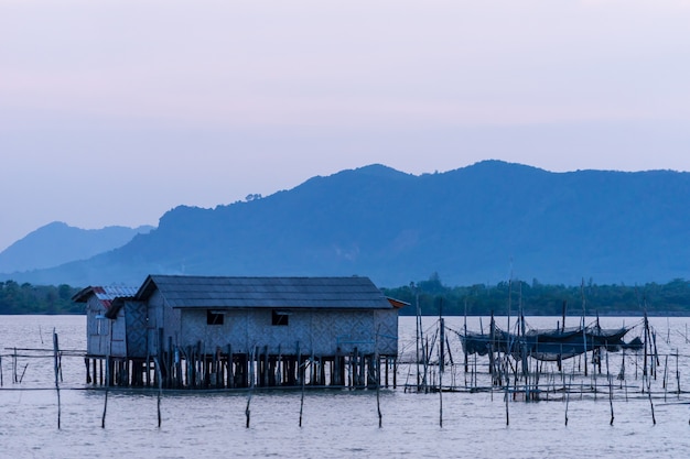 Pescador cabana no meio do lago Songkhla com gaiolas de pesca e montanhas